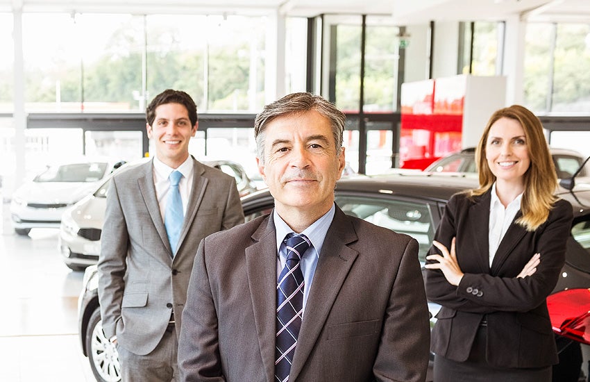 Businessmen standin in dealership showroom